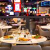 Elegant indoor dining table with gourmet cuisine, champagne, and casino chips, capturing Malta’s VIP culinary and gaming experience