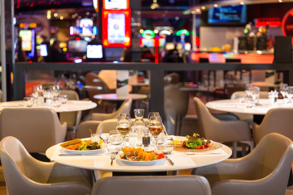 Elegant indoor dining table with gourmet cuisine, champagne, and casino chips, capturing Malta’s VIP culinary and gaming experience