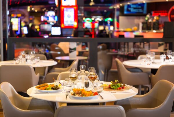Elegant indoor dining table with gourmet cuisine, champagne, and casino chips, capturing Malta’s VIP culinary and gaming experience